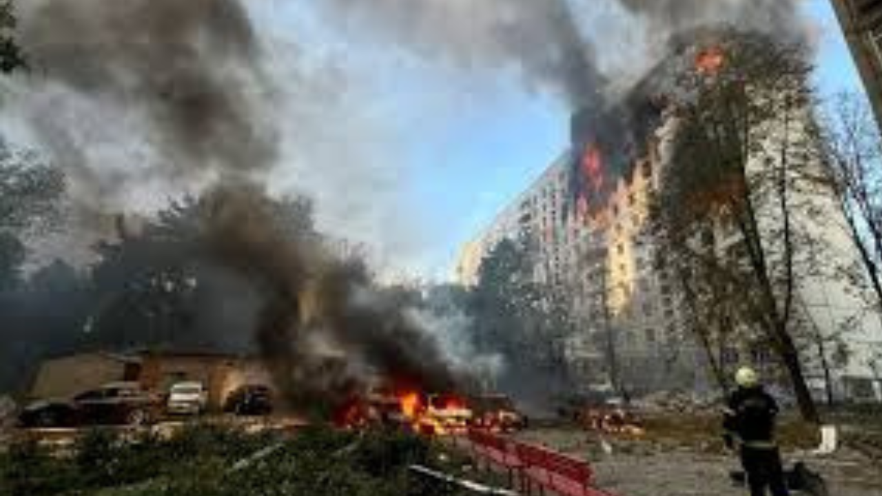 A single figure, likely a firefighter, is visible in the bottom right corner of the image, working to extinguish the blaze. The scene is chaotic and destructive, highlighting the devastation caused by the fire.